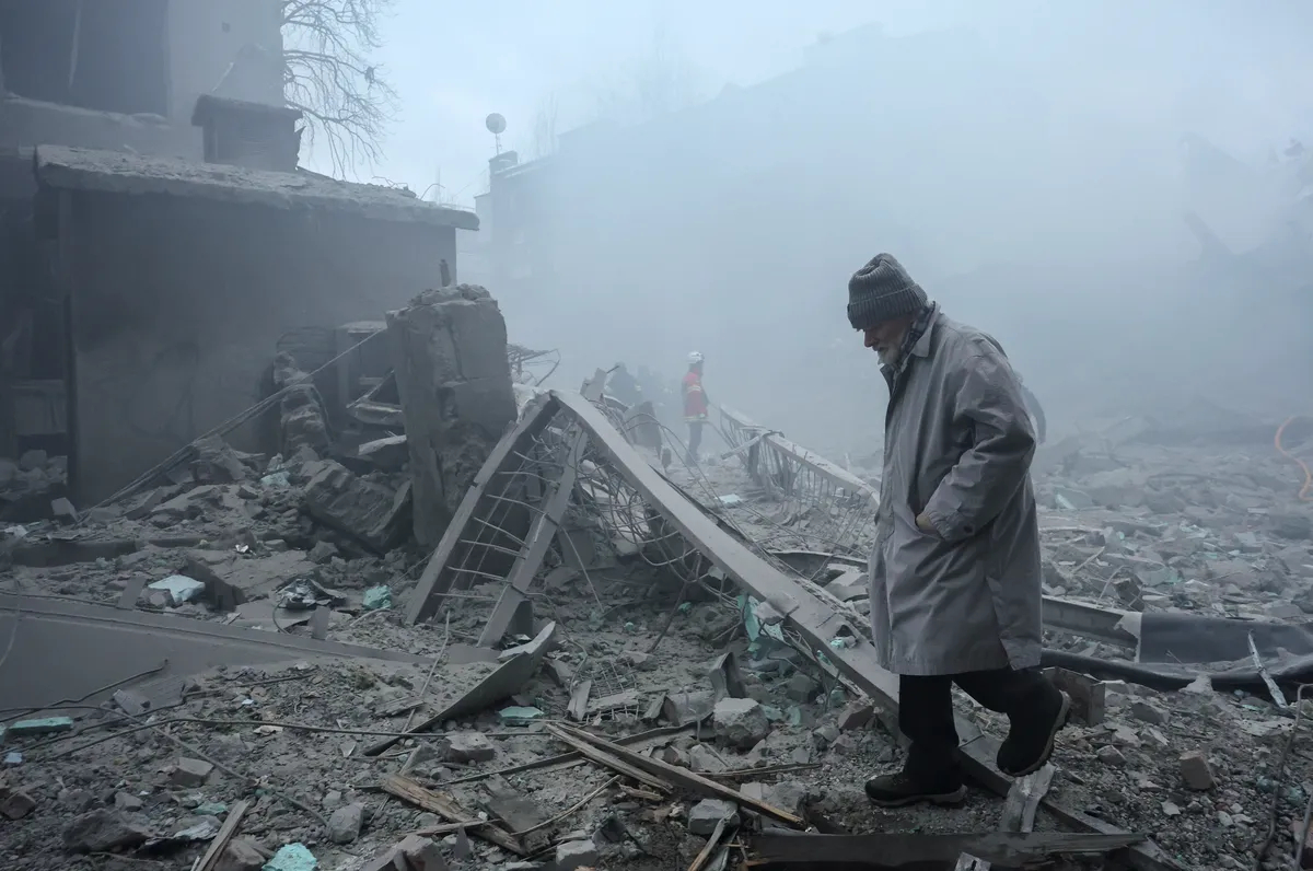 A man walks through the rubble after a Russian strike on a residential area in Kharkiv, northeastern Ukraine, 2 January 2026. Photo: EPA / Sergey Kozlov
