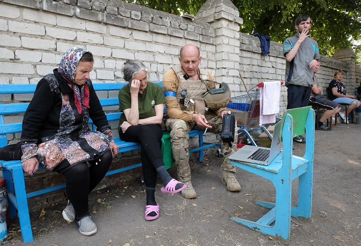 A Ukrainian serviceman talks to Sudzha residents on 21 August 2024. Photo: EPA-EFE