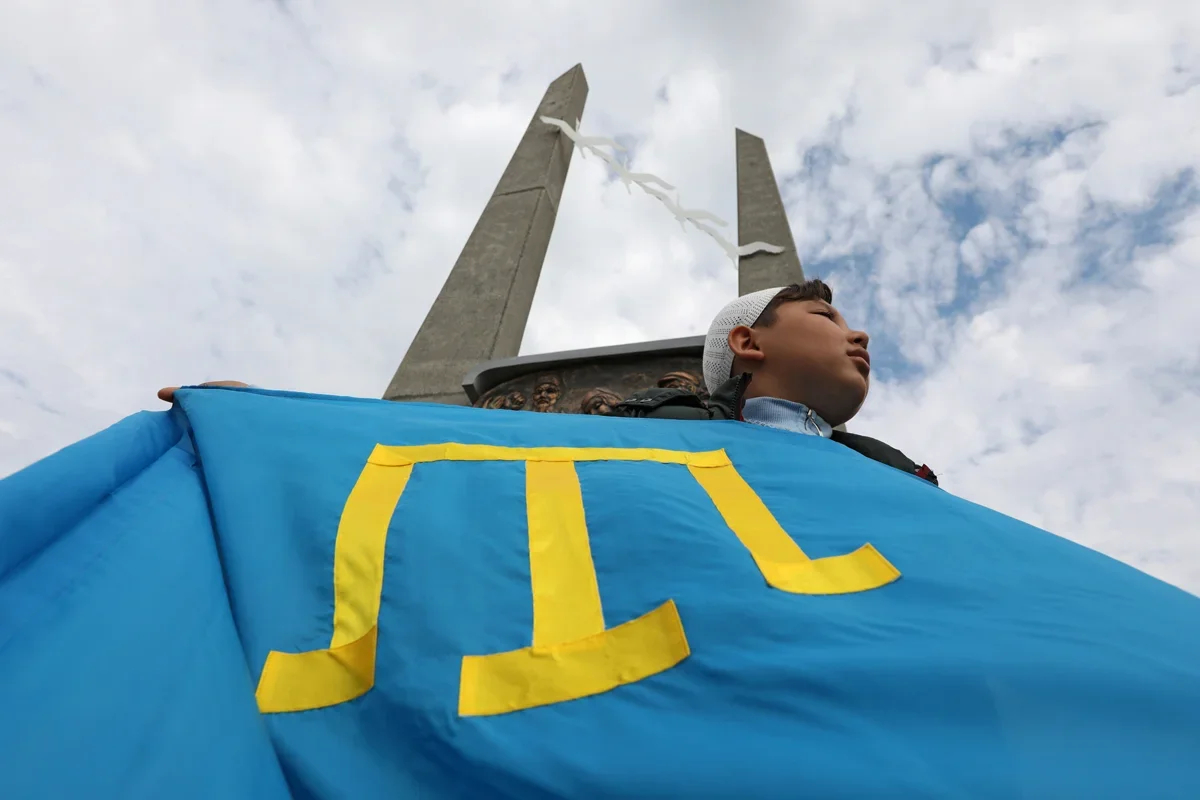 A boy holds the Crimean Tatar flag at a demonstration marking their mass deportation in 1944, Yevpatoria, Ukraine, 18 May 2021. Oleksiy Pavlyshak/ Reuters / Scanpix