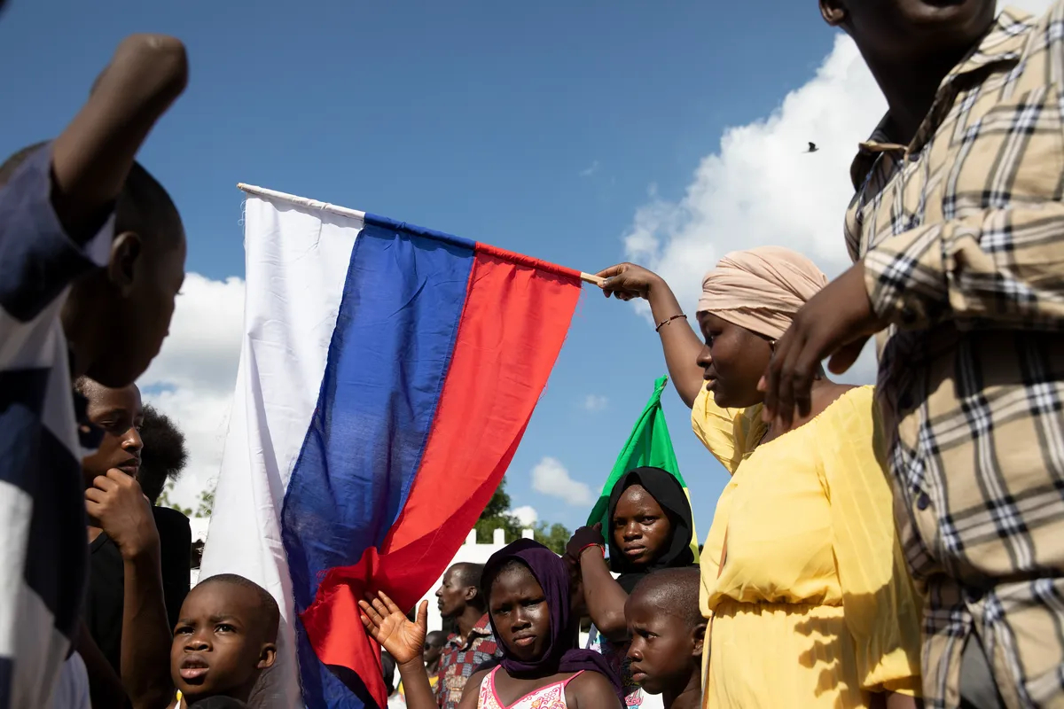 A demonstrator waves a Russian flag during Independence Day celebrations in Bamako, Mali, 22 September 2022. Photo: EPA-EFE / HADAMA DIAKITE