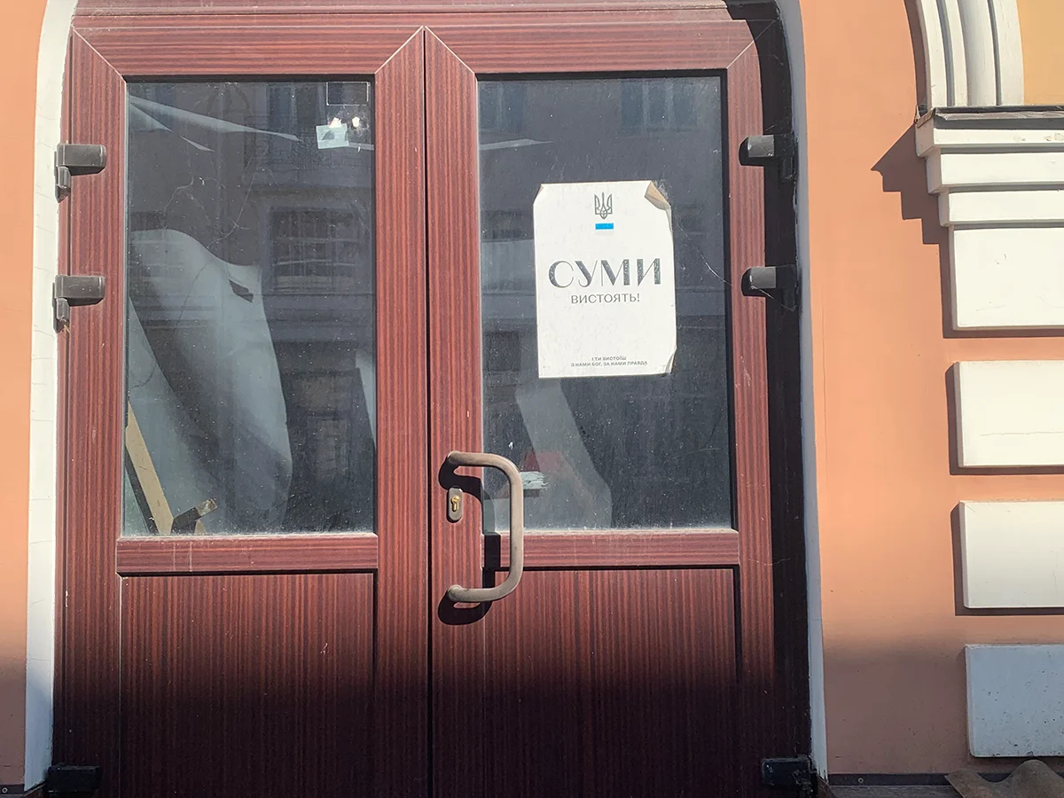 Листок «Сумы выстоят!» на двери дома, поврежденного взрывом. Фото: Ольга Мусафирова