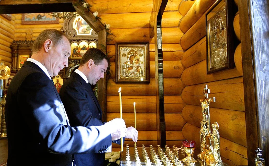 Владимир Путин и Дмитрий Медведев ставят свечи в часовне на территории резиденции главы государства в память о погибших в катастрофе под Смоленском. Фото: Wikimedia Commons , CC BY 4.0