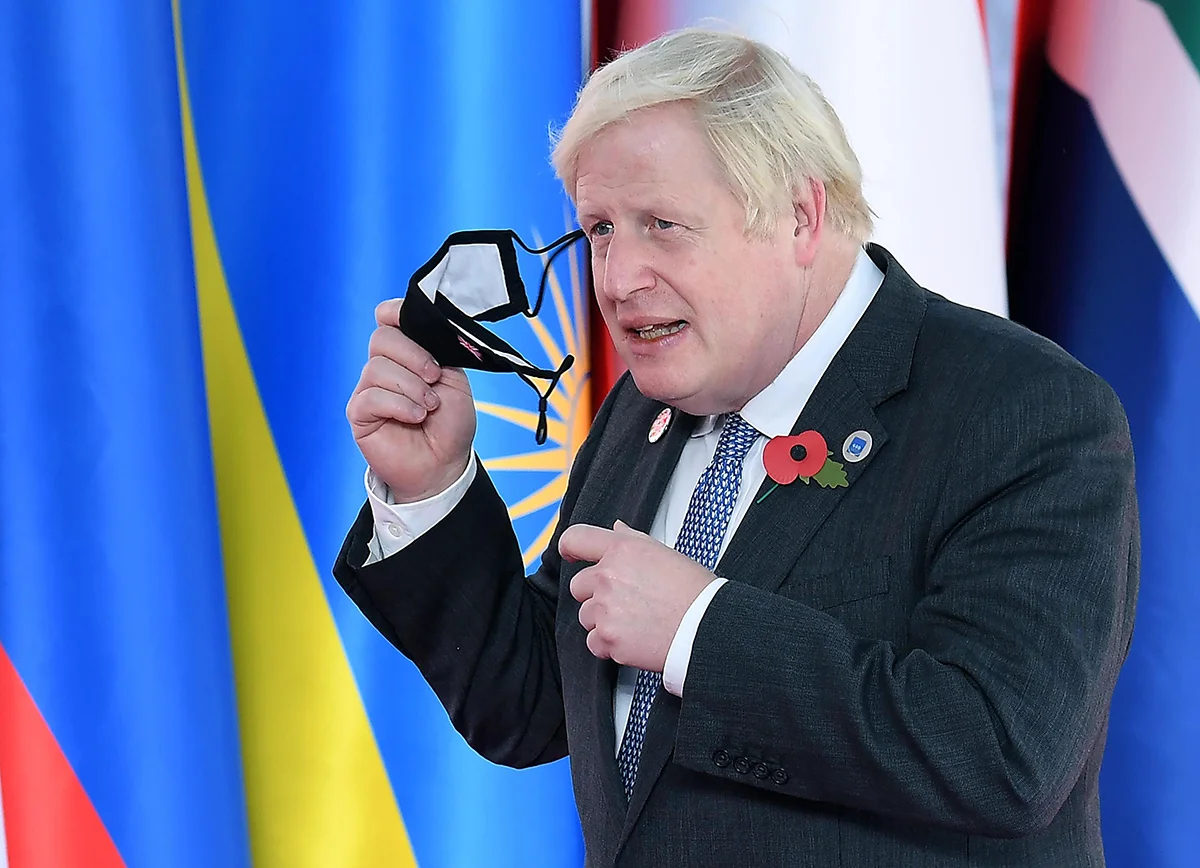 Премьер-министр Великобритании Борис Джонсон снимает маску, прибыв на саммит лидеров G20 в конгресс-центр La Nuvola в Риме, Италия, 30 октября 2021 года. Фото: Ettore Ferrari / EPA-EFE