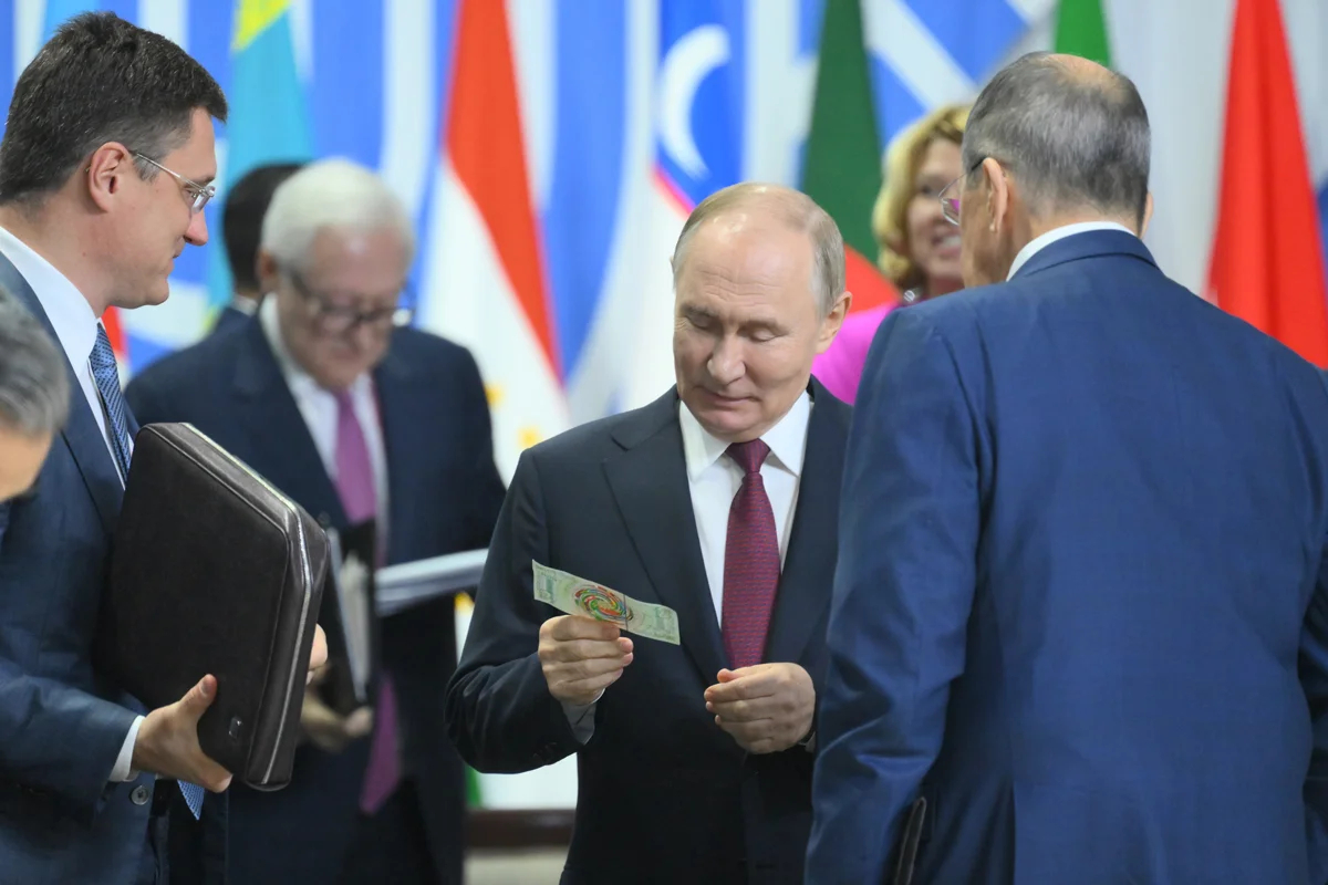 Владимир Путин с «банкнотой БРИКС» на саммите в Казани, 23 октября 2024 года. Фото: Станислав Красильников / brics-russia2024.ru