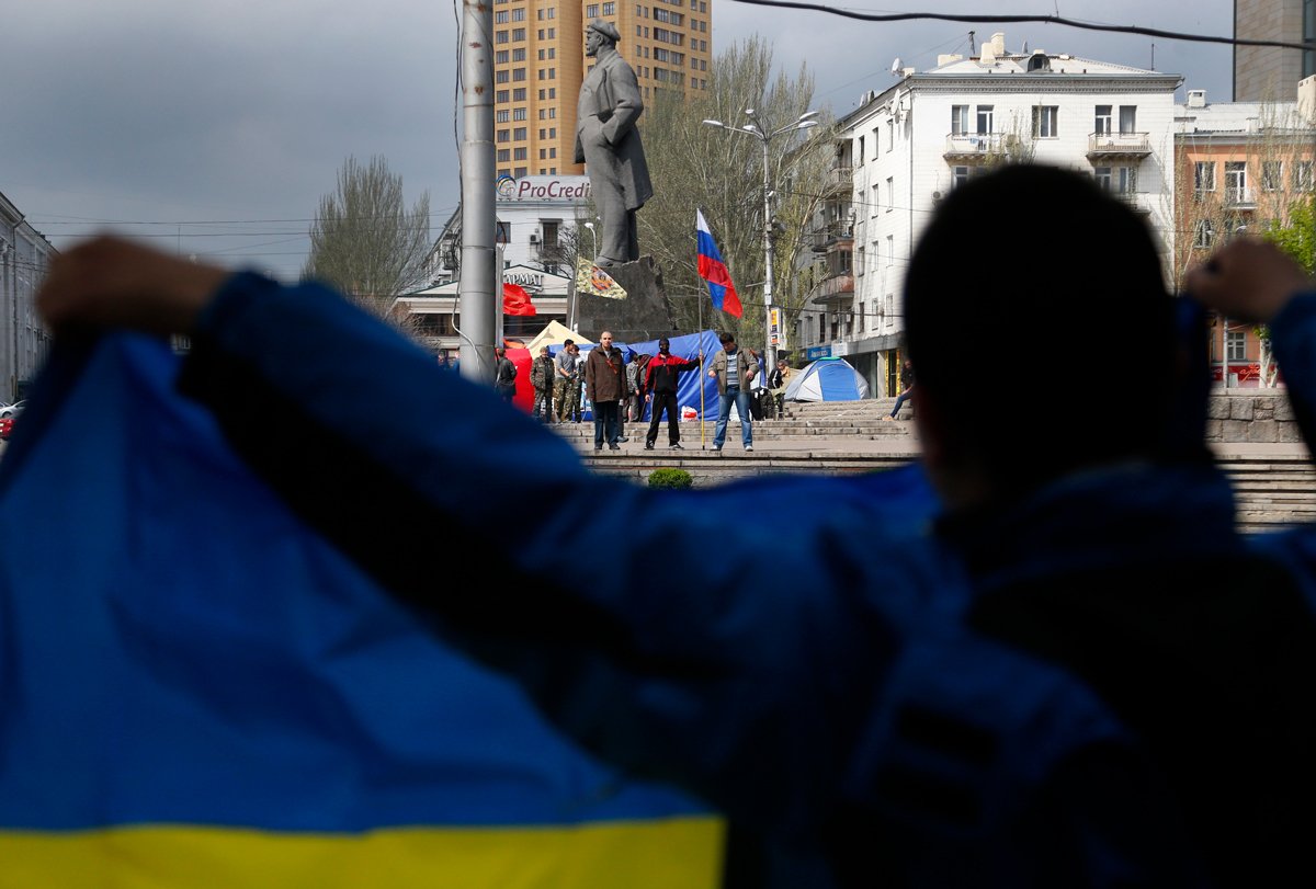 Протестующий с украинским флагом напротив пророссийских активистов в Донецке, Украина, 22 апреля 2014 года. Фото: Sergei Grits / AP Photo / Scanpix / LETA