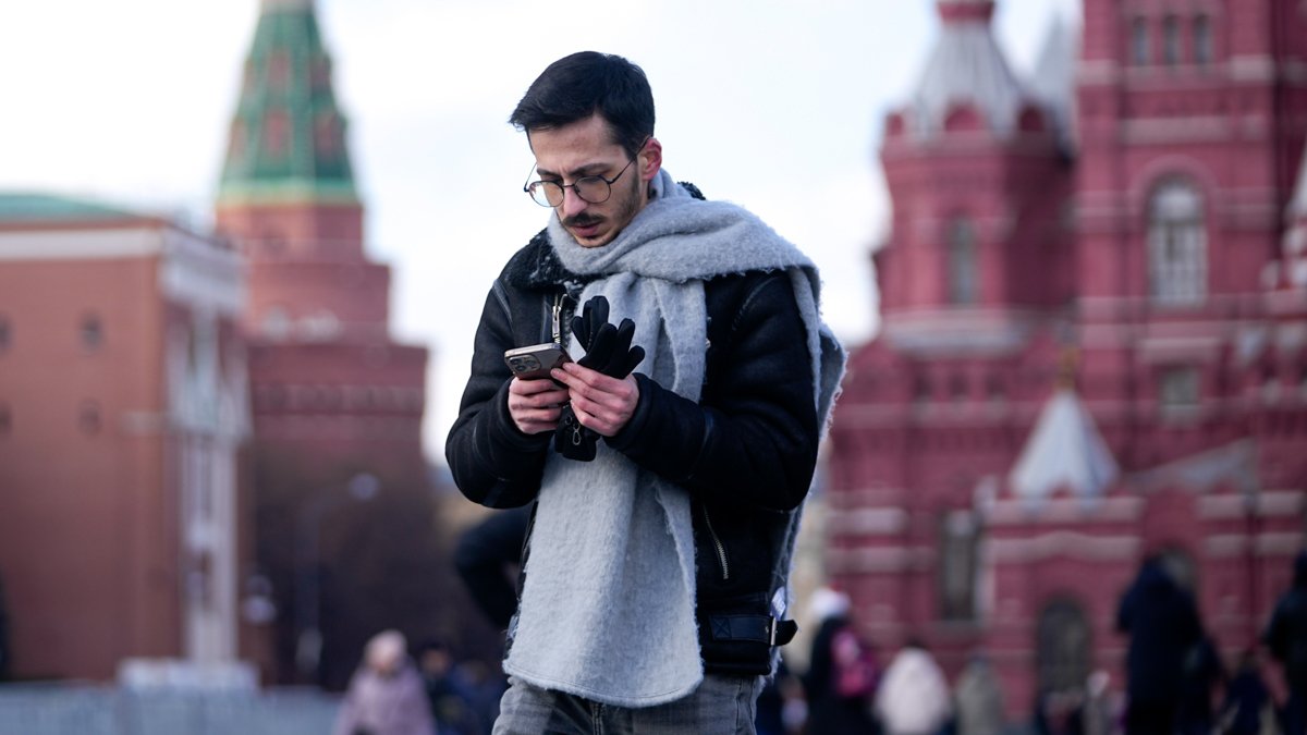 Мужчина смотрит в свой смартфон, пересекая Красную площадь в Москве. Фото: Павел Бедняков / AP Photo / Scanpix