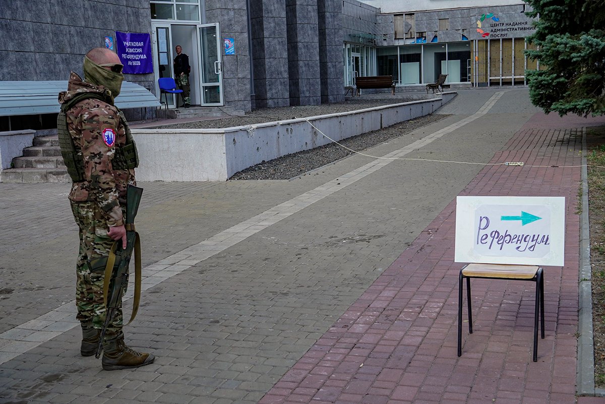Российский военнослужащий возле указателя с надписью «Референдум» на открытом избирательном участке во время голосования на референдуме о присоединении регионов Украины к России в Мариуполе, Украина, 25 сентября 2022 года. Фото: EPA-EFE